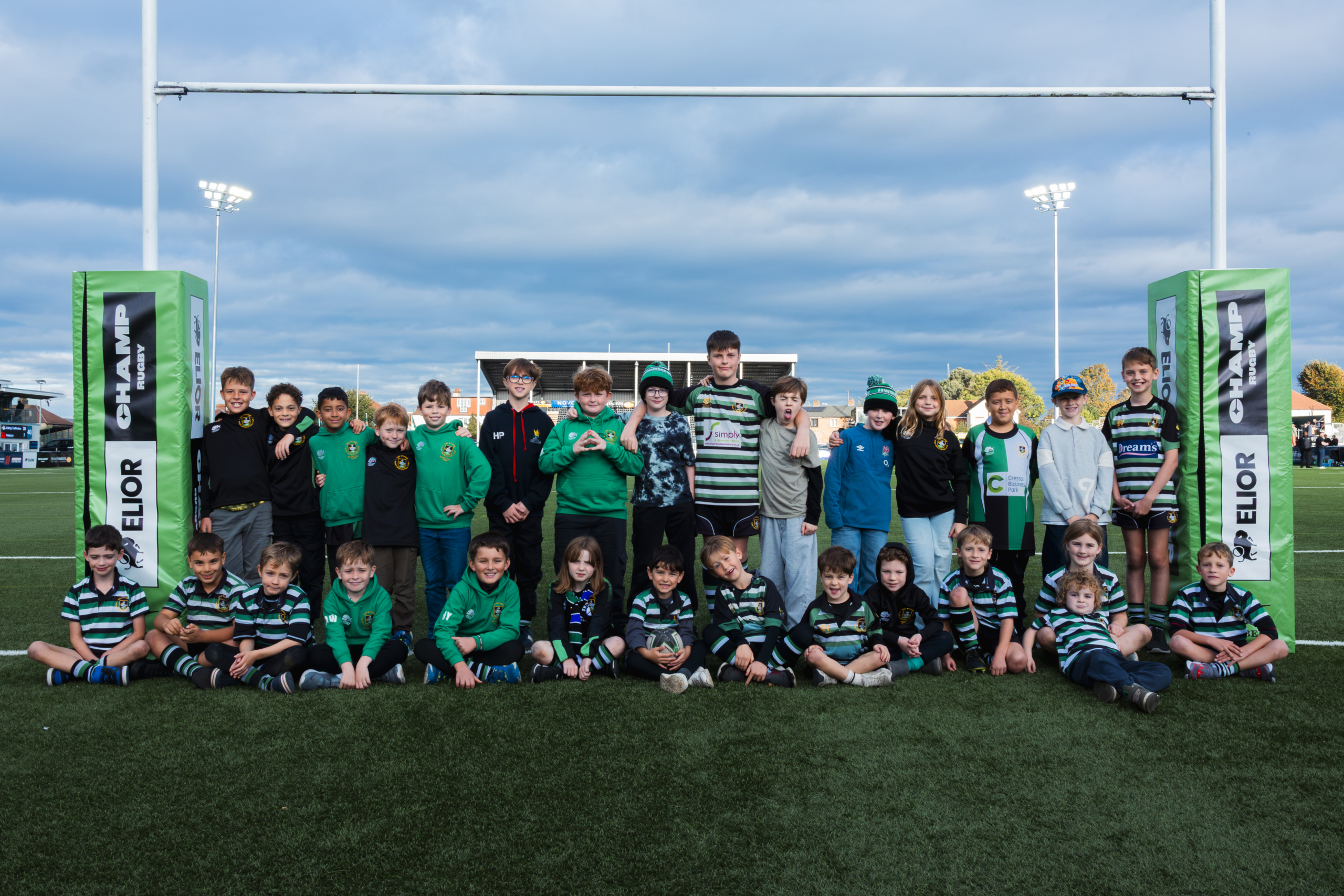 Mini rugby players from the six festival teams in a half-time group photo under the Elior Champ Rugby posts